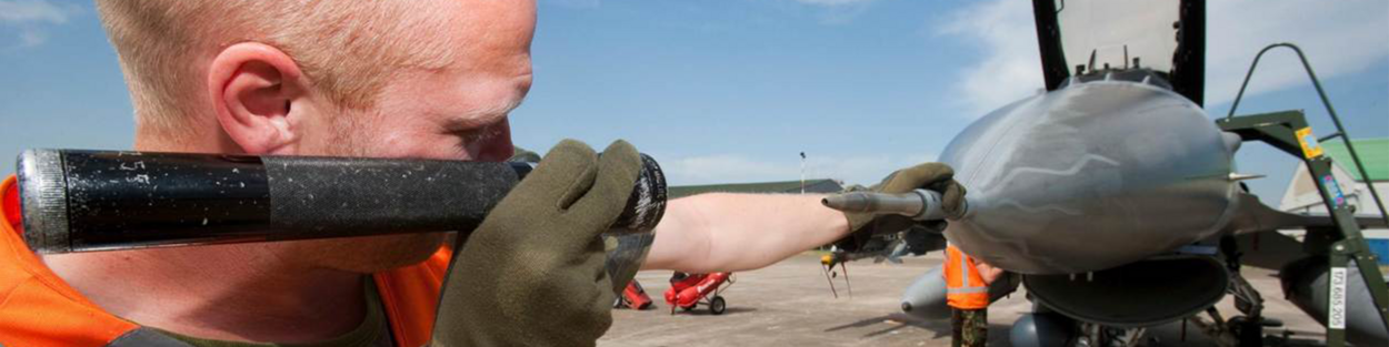een foto van een man die de neus van een straaljager inspecteert - ter illustratie van de Inspectie Veiligheid en Defensie