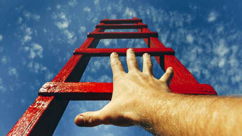 Decoratieve afbeelding die het thema Over grenzen symbolisch uitbeeldt in de vorm van een hand op een ladder die naar de wolkenlucht wijst