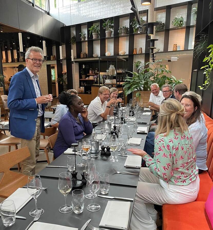 afbeelding van etentje met ongeveer 12 vrolijke mensen