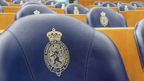 Een close-up beeld van stoelen in de Tweede Kamer