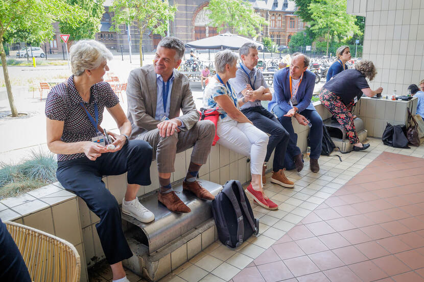 Mensen eten lunch op een rijtje gezeten op een muurtje